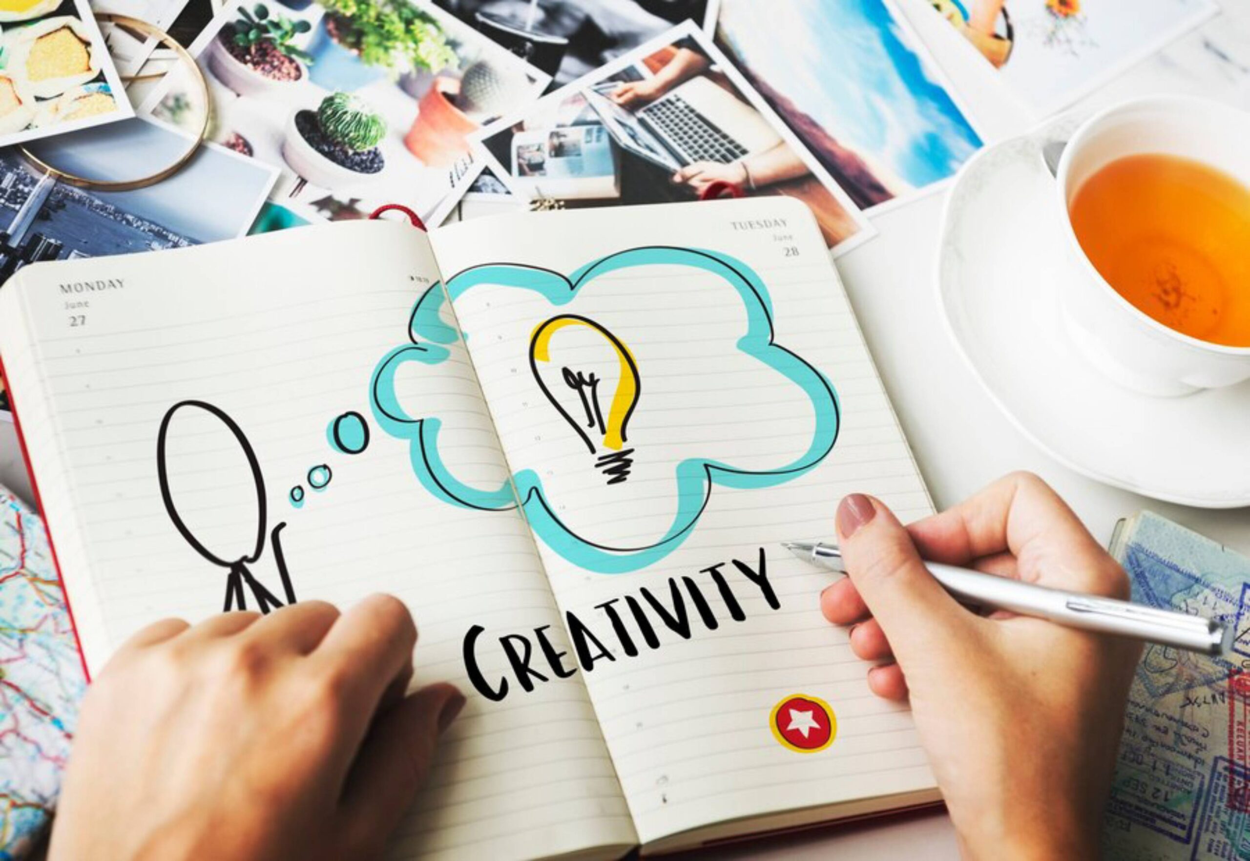 A hand holds a pen over an open notebook with a thought bubble, emphasizing Creativity and an illustration of a light bulb.
