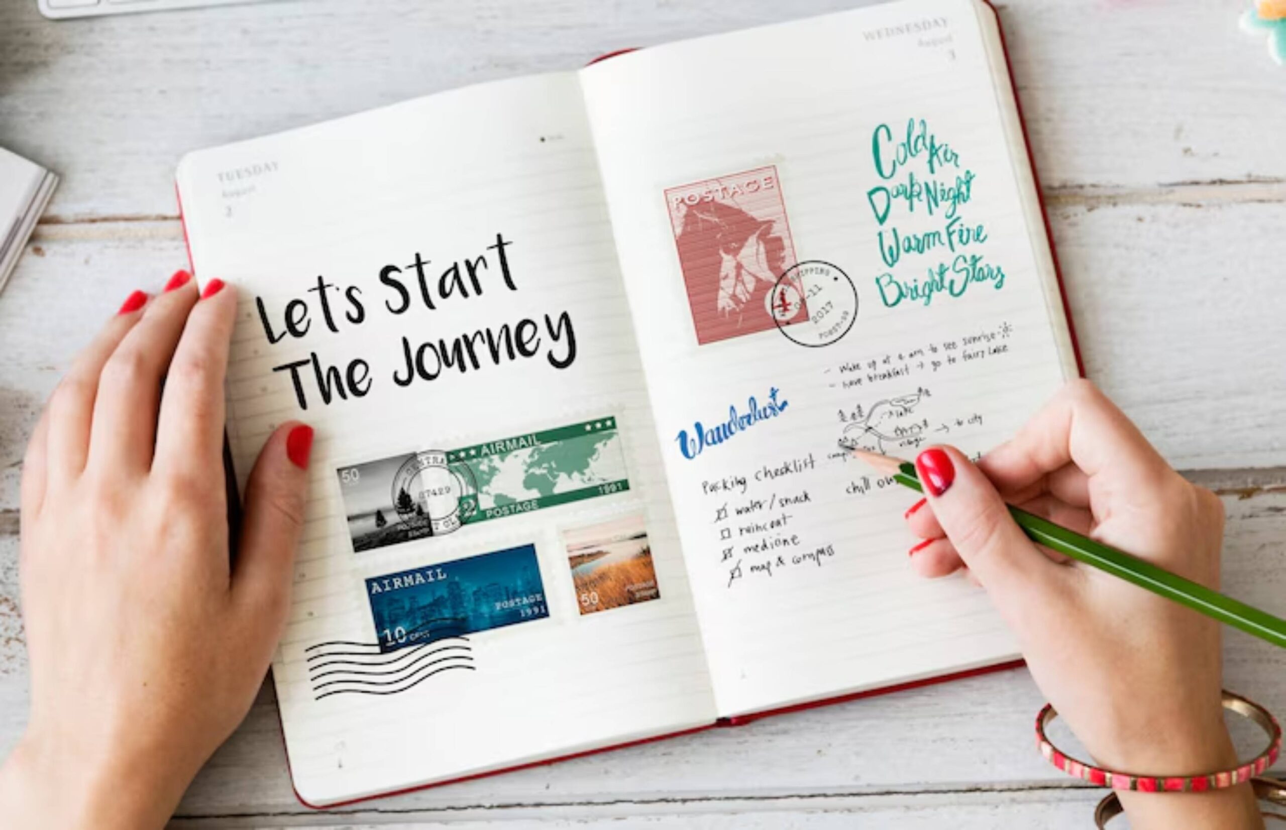 A hand with red nails writes in a travel journal filled with stamps, notes, and a checklist titled Wanderlust.